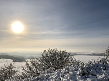 Scenic view of snow covered field against sky