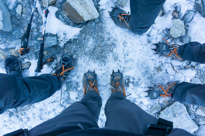 Low section of people standing on snow covered landscape