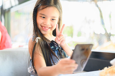 Portrait of smiling girl holding smart phone