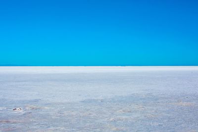 Scenic view of desert against clear blue sky