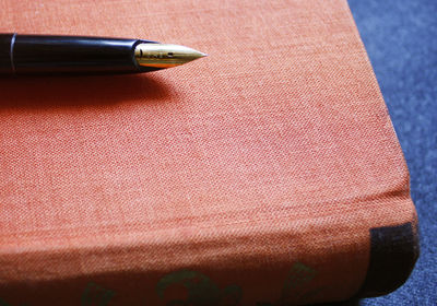 High angle view of book and pen on table