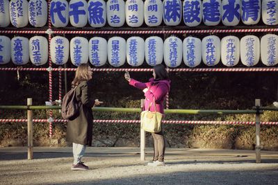 Full length of woman standing by railing