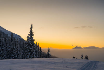 Scenic view of snow covered landscape against sky during sunset