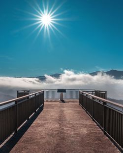 Sun shining over bridge on sunny day