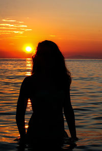 Silhouette woman at beach during sunset