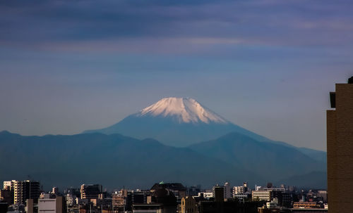 Aerial view of city against cloudy sky