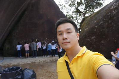 Portrait of man standing against rock formations