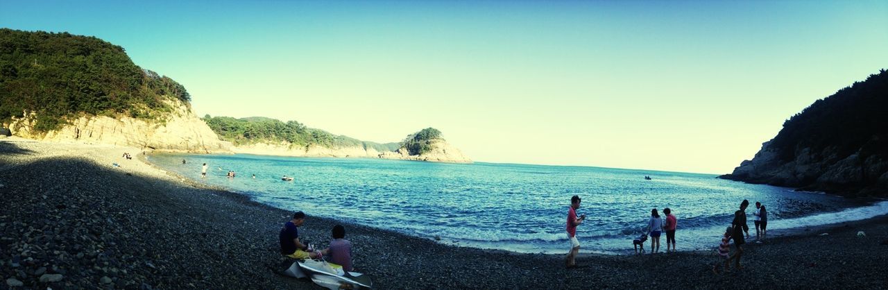 beach, water, sea, leisure activity, lifestyles, shore, vacations, large group of people, clear sky, copy space, men, person, blue, sand, scenics, enjoyment, beauty in nature, weekend activities, tourist