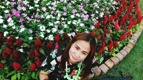 Portrait of smiling young woman against plants