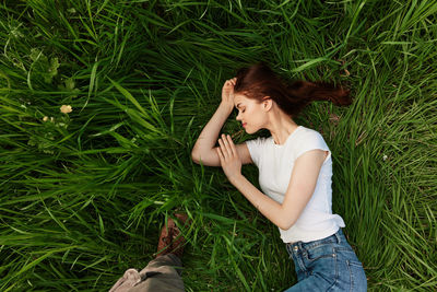 Young woman sitting on grassy field