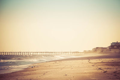 Scenic view of beach against clear sky during sunset