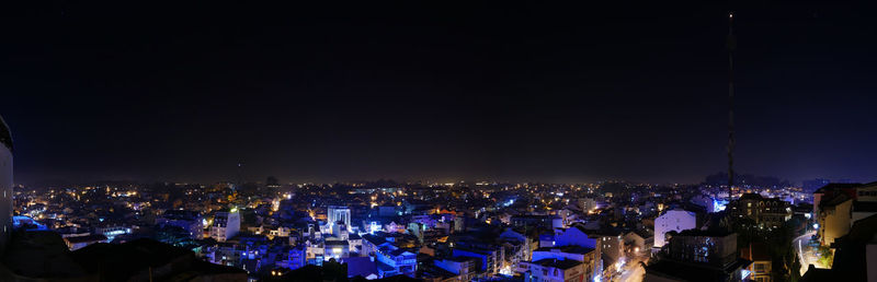 High angle view of illuminated cityscape against sky at night