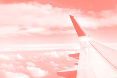 Airplane wing against sky during sunset