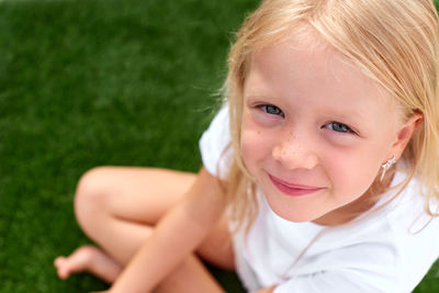 Close-up of young woman lying on field