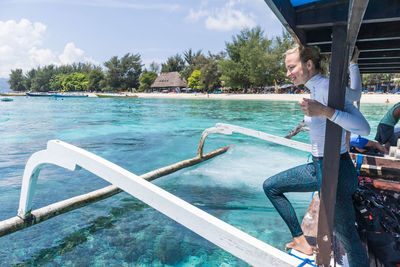 Side view of person standing by swimming pool against sky