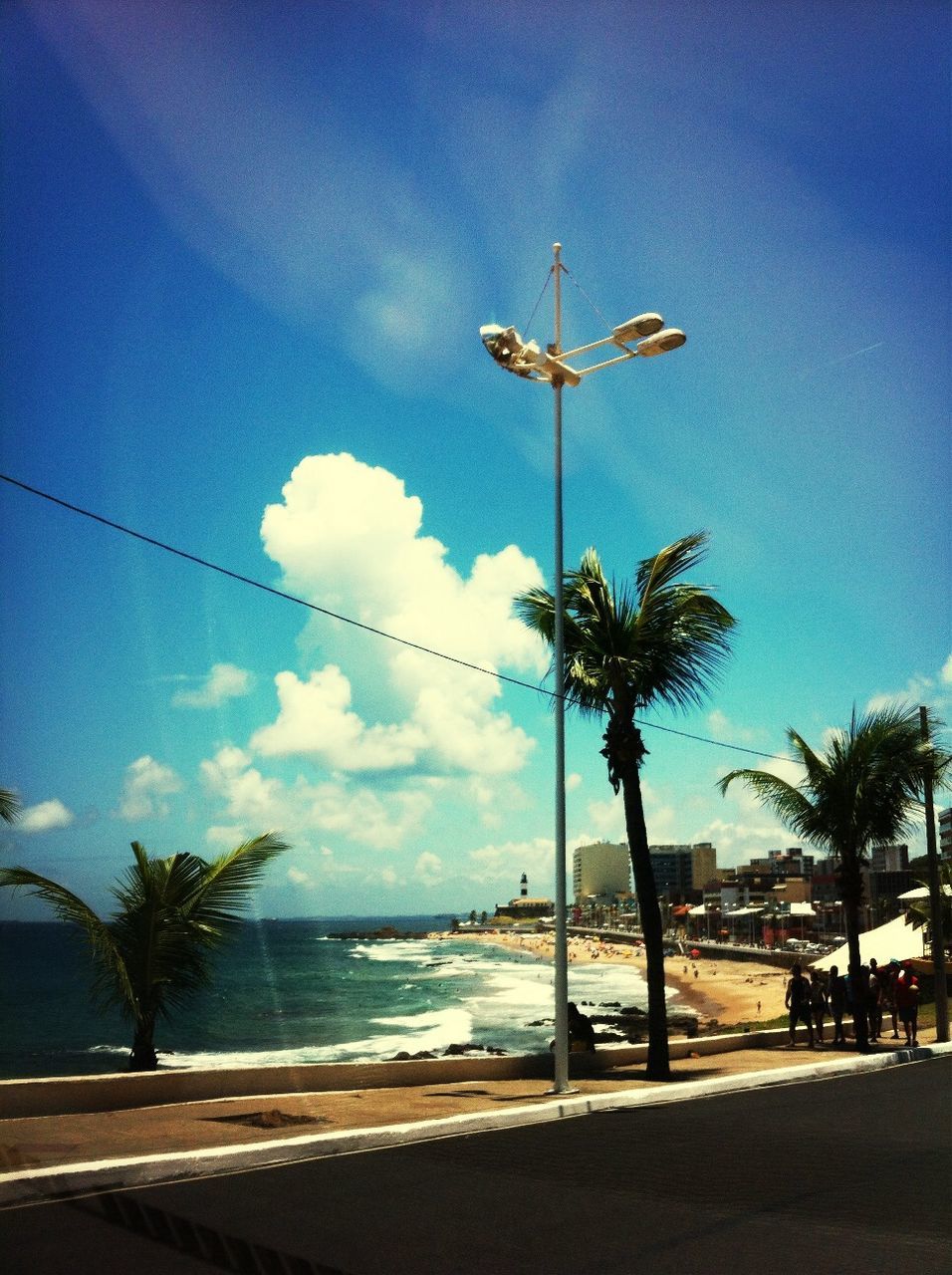 palm tree, tree, sky, water, sea, silhouette, cloud - sky, tranquility, blue, street light, tranquil scene, beach, scenics, nature, road, cloud, beauty in nature, horizon over water, tree trunk, outdoors