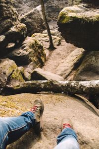 Low section of man sitting on rock