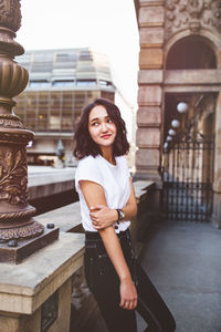 Young asian woman in a white t-shirt, architecture in background. street portrait, lifestyle concept
