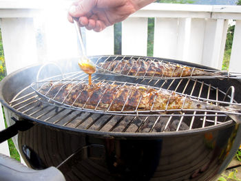 Person preparing food on barbecue grill