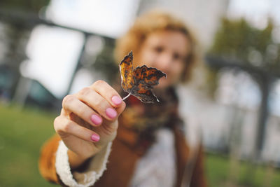 Close-up of woman holding dry leaf