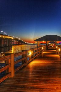 Illuminated bridge over canal against clear sky at night