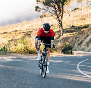 Side view of man riding bicycle on road