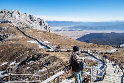 Man standing on snowcapped mountain against sky