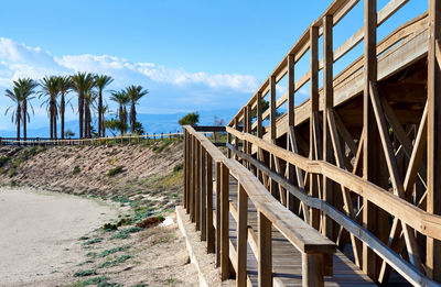 Boardwalk at park against blue sky