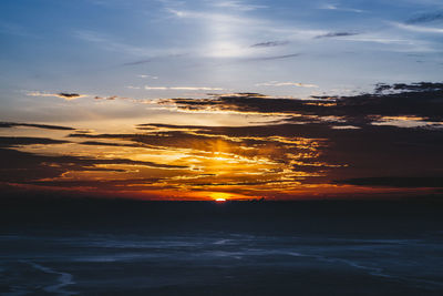Idyllic shot of sea against orange sky during sunrise