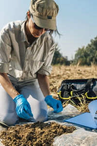 Agronomist analyzing soil on field