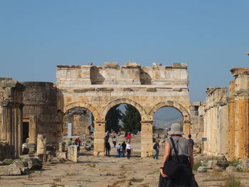 People at historical building against clear sky