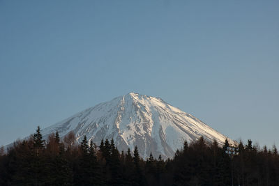 Low angle view of snowcapped mountain against clear sky