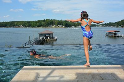 Rear view of girl jumping in lake