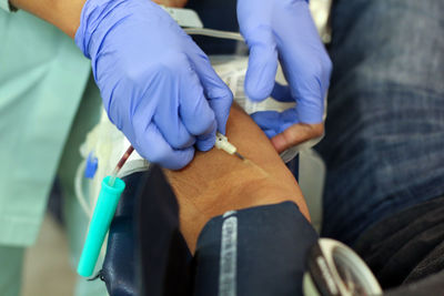 Cropped image of doctor preparing patient for blood donation