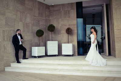 Well dressed bride and groom standing in corridor