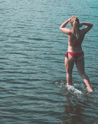 Rear view of woman standing in sea