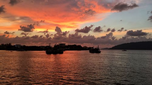 Silhouette boats in sea against sky during sunset