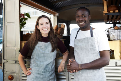 Portrait of smiling young couple standing outdoors