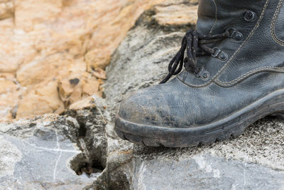 Low section person wearing shoes on rock