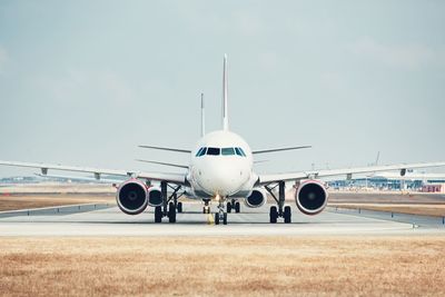 Airplane on runway against sky