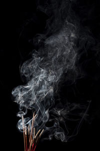 Close-up of smoke emitting from black background