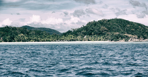 Scenic view of sea and mountains against sky