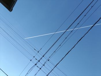 Low angle view of cables against clear blue sky