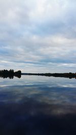 View of calm lake against cloudy sky