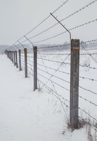 Snow covered field against clear sky