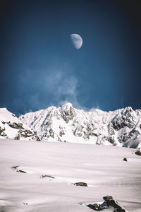 Scenic view of snowcapped mountains against clear blue sky