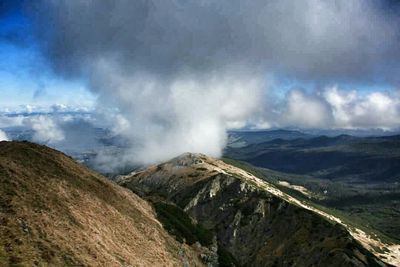 Scenic view of mountains against cloudy sky