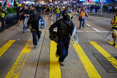 Group of people walking on road in city