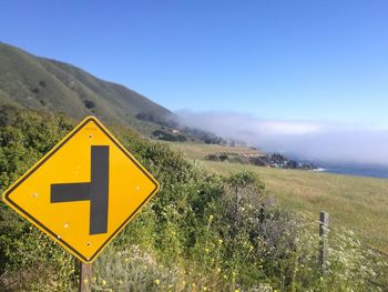 Road signs on landscape against sky