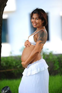 Portrait of happy pregnant woman standing outdoors